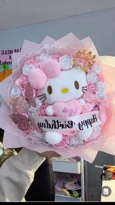 a hello kitty birthday card with pink flowers and a tiara on it's head