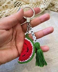 a hand holding a keychain that has a watermelon on it and the words peace written in small letters