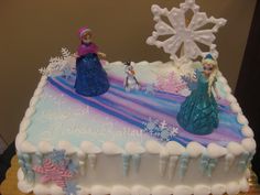 there is a birthday cake decorated with frozen princesses and snowflakes