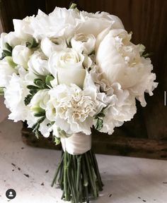 a bouquet of white flowers sitting on top of a table