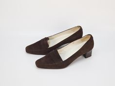 Elevate your footwear collection with these Vintage Suede Leather Loafers in rich dark brown by O.I.S, expertly crafted in Spain. These slip-on shoes feature a sophisticated square toe and a mid stacked heel, blending classic design with modern comfort. The soft suede leather adds a luxurious touch, making them perfect for both casual outings and dressier occasions. With their timeless style and durable construction, these loafers are a versatile addition to any woman's wardrobe. Ideal as a thou Brown Low Heel Loafers For Business, Brown Slip-on Heels For Business Casual, Classic Brown Heels For Business Casual, Vintage Brown Loafers For Office, Brown Low Heel Loafers For Formal Occasions, Formal Brown Slip-on Heels, Brown Low Heel Business Loafers, Brown Slip-on Heels For Formal Occasions, Office Slip-on Brown Heels