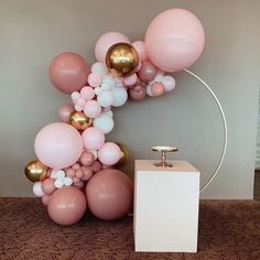 a balloon arch with pink, white and gold balloons