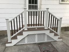 a porch with white railings and brown steps