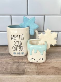 two ceramic mugs sitting on top of a wooden table