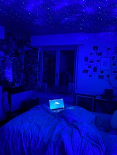 a laptop computer sitting on top of a bed in a room with blue walls and stars