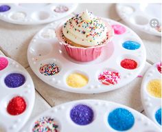 there is a cupcake with sprinkles on it sitting on a plate