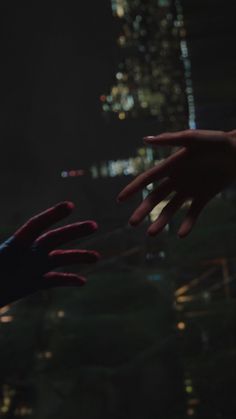 two hands reaching for each other in front of a cityscape with skyscrapers