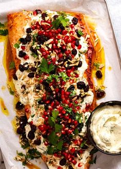 the fish is covered in herbs and garnished with olives, cilantro, and parsley