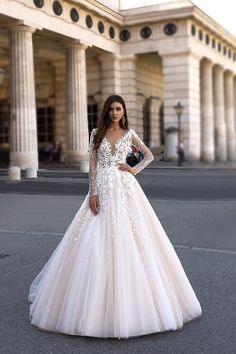 a woman in a wedding dress standing on the street