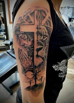 a man with a cross and lion tattoo on his arm