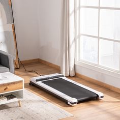 a living room with a couch, coffee table and an exercise mat on the floor