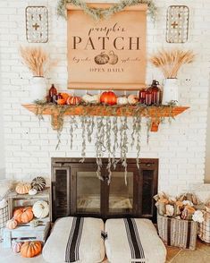 a fireplace mantel decorated with pumpkins and greenery