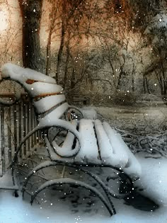 a bench covered in snow next to trees