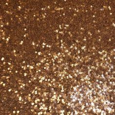 an image of gold glitter textured paper with some brown and white dots on it