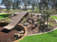 a wooden slide sitting in the middle of a park