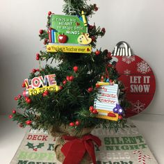 a small christmas tree decorated with magnets and writing on it's branches is shown