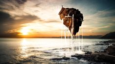 an image of a rock sticking out of the water at sunset or sunrise with waves coming from it