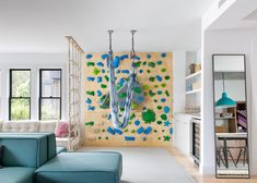 a living room filled with furniture and a climbing wall