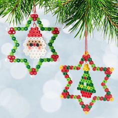 two ornaments hanging from a christmas tree on a blue background with bokem beads