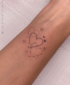 a small heart tattoo on the arm