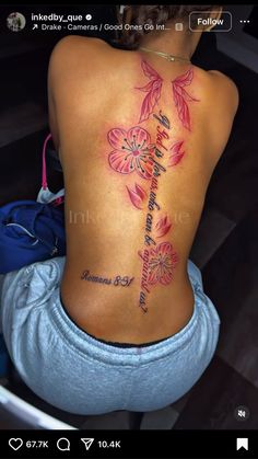 the back of a woman's lower back tattoo with flowers and words on it