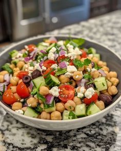 a salad with chickpeas, tomatoes, cucumbers and feta cheese