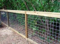 the fence is made of wood and wire with green plants growing on top of it