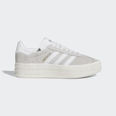 It wouldn't be a list of adidas' most iconic shoes without the Gazelle. First worn on indoor courts in the '70s, the suede shoe is gaining new fans to this day. Now the style you covet is lifted up to new heights. It's stacked three layers high, for a new perspective on the classic style. The details stay sporty with buttery-soft suede and serrated 3-Stripes. A metallic-gold "Gazelle" is the final stamp of our heritage. Cutest Shoes For Teens, Casual Shoes For Women Sneakers, Shoes To Ask For For Christmas, Women’s Adidas Sneakers, Cute Dressy Shoes, Adidas Shoes Women Platform, Trendy Everyday Shoes, Gray Adidas Shoes Outfit, 2025 Clothing Trends