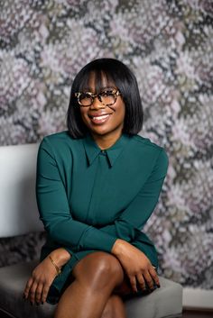 a woman sitting on top of a chair wearing glasses