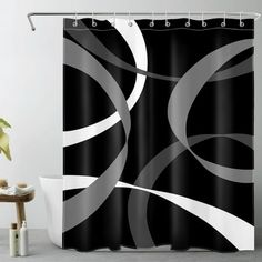 a black and white shower curtain with silver circles on the bottom, in front of a bathtub