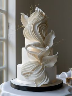 a three tiered white wedding cake on a table