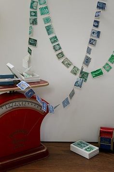 there is a ruler and some stamps on the wall next to a desk with a clock