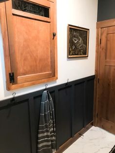 a bathroom with wooden cabinets and marble counter tops, along with a towel rack on the wall