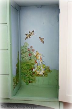 an open cabinet with a painting on the door and some birds flying over it in the background