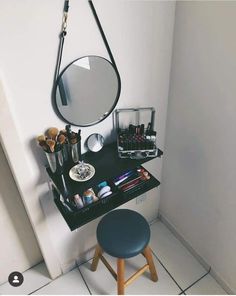 a vanity with a mirror, stool and makeup on it