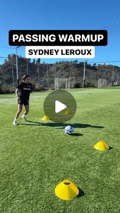 a woman is running around yellow cones on the grass