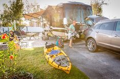 a man standing next to a yellow kayak in front of a motor home