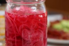 a jar filled with red liquid sitting on top of a table