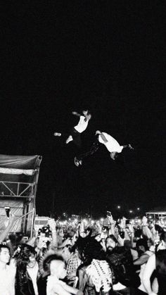 a man flying through the air while riding a skateboard in front of a crowd