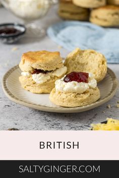 two biscuits with jam and cream on them sitting on a plate