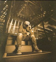 a man sitting on top of a set of stairs holding a cell phone to his ear