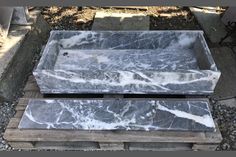 two marble trays sitting next to each other on top of some wood pallets