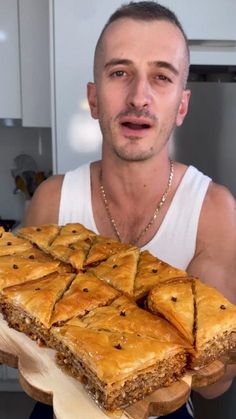 a man holding a large slab of food in front of his face and looking surprised at the camera