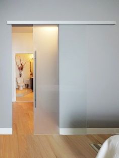 an empty bedroom with sliding glass doors leading to the bathroom and another room in the background