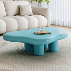 a blue coffee table sitting on top of a rug in front of a white couch