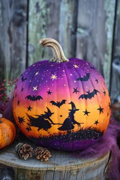 a painted pumpkin sitting on top of a wooden stump