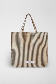 The Stripe Market Tote Bag is a practical accessory crafted from durable cotton canvas in NYC. Available in red and cream stripe or classic black and cream stripe, its compact size makes it perfect for everyday essentials, while sturdy handles ensure comfortable carrying. Orseund Iris offers a 14-day exchange & return policy for all items except for final sale pieces. Everyday Bags With Striped Lining And Double Handle, Striped Canvas Shoulder Bag For Daily Use, Striped Canvas Rectangular Bags, Striped Cotton Travel Bags, Daily Use Striped Bag With Double Handle, Canvas Bags With Striped Lining For Daily Use, Striped Double Handle Bags For Daily Use, Canvas Tote Bag With Striped Lining, Striped Double Handle Bag For Daily Use