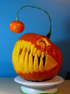 a carved pumpkin with teeth and fangs on it's head, sitting on top of a table