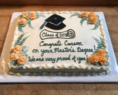 a cake that has been decorated with flowers and a graduation cap on it, sitting on a table