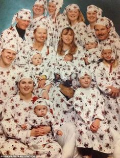 a group of people in pajamas and hats posing for a photo with their babys